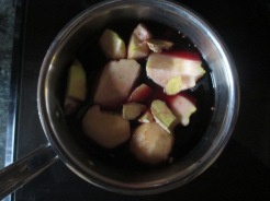 quartered apples in wine in saucepan