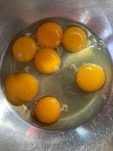 broken eggs and yolks in bowl