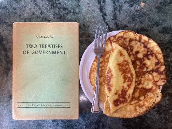 book Locke's two treatises, and plate with pancakes and fork