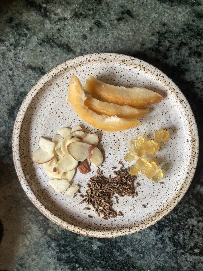 spices and seasonings on plate: caraway seeds, sliced almonds, candied citron and orange peel